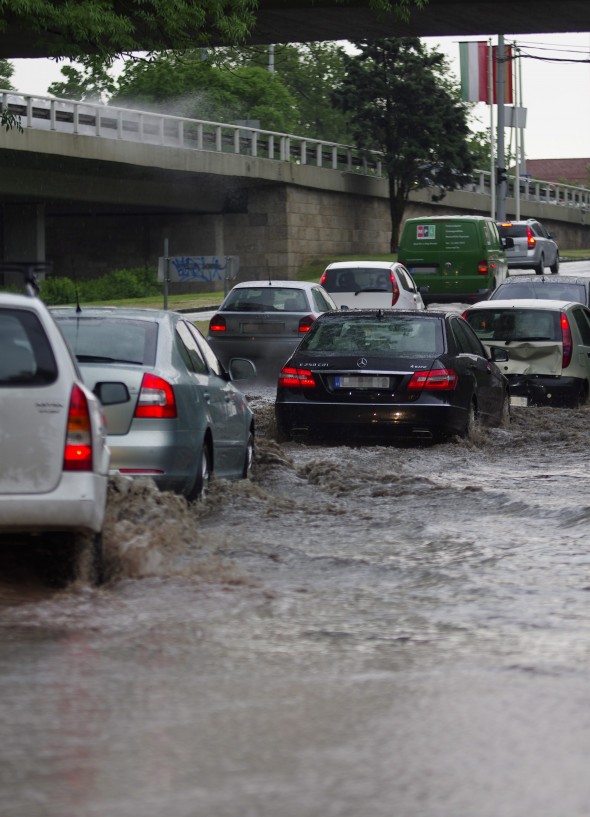 Autók haladnak az összegyűlt csapadékvízben az Erzsébet híd budai hídfőjénél 2013. május 6-án. A várható heves zivatarok miatt Pest megyére elsőfokú figyelmeztetést adott ki az OMSZ