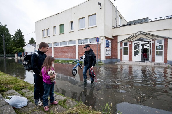 Gyerekek holmiját menti ki édesapjuk a várható magas vízállás miatt zárva tartó Győri Vízisport Egyesület csónakházából Győrben