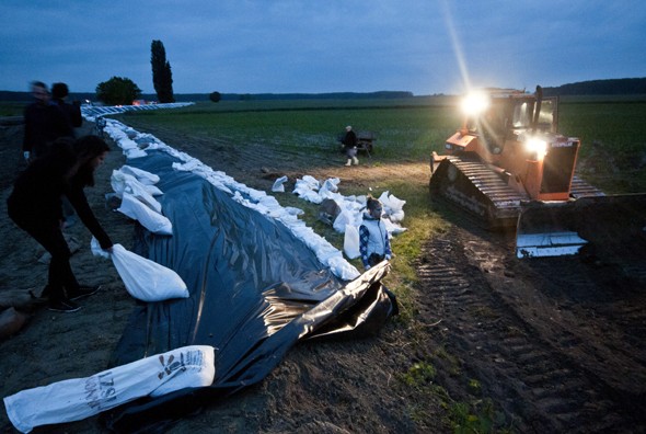 Önkéntesek homokzsákokkal erősítik meg a töltést a közelgő árvíz miatt Dunaszentpál határában