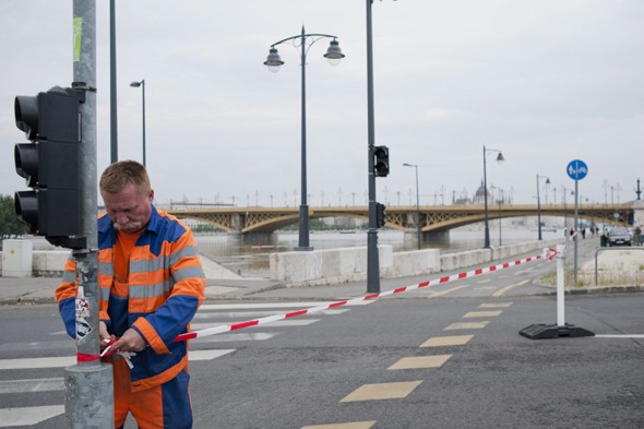 A Budapesti Közlekedési Központ (BKK) dolgozója az árvízi védekezés miatt lezárja a budai Slachta Margit rakpartot