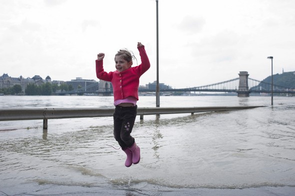 Egy kislány ugrál a vízben a Duna által elöntött fővárosi Sztehlo Gábor rakpart lehajtójánál 2013. június 7-én. A háttérben a Lánchíd látható