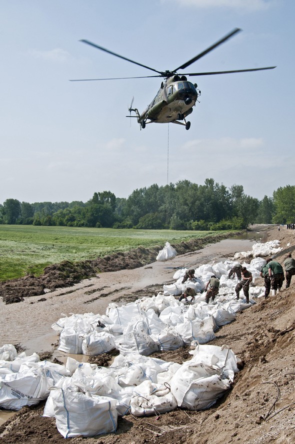 A honvédség helikoptere homokzsákokat szállít a megcsúszott győrújfalui gát erősítéséhez 