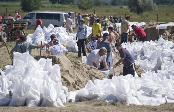 A Duna áradása miatt önkéntesek homokzsákokat töltenek a Duna nyárigátjánál Solt határában