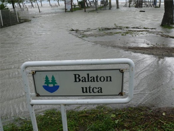 A viharos szél miatt kicsapódó hullámok által elárasztott parti sétány Balatonfenyvesen
