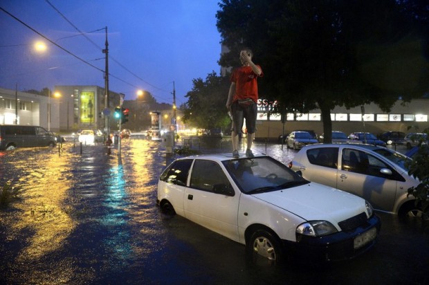 Egy férfi áll elakadt autója tetején a vízzel elöntött XIII. kerületi Béke térnél 2015. augusztus 17-én. Egy óra alatt több eső esett a főváros belső részén, mint az augusztusi havi átlag.