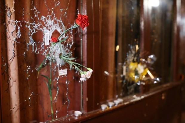 Gyolyók ütötte lyukakba tűzött virágok a párizsi Rue Alibert-en 2015. november 14-én.